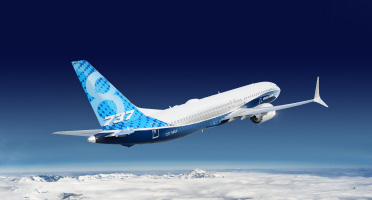 A Boeing 737 MAX 8 aircraft flying above the clouds.