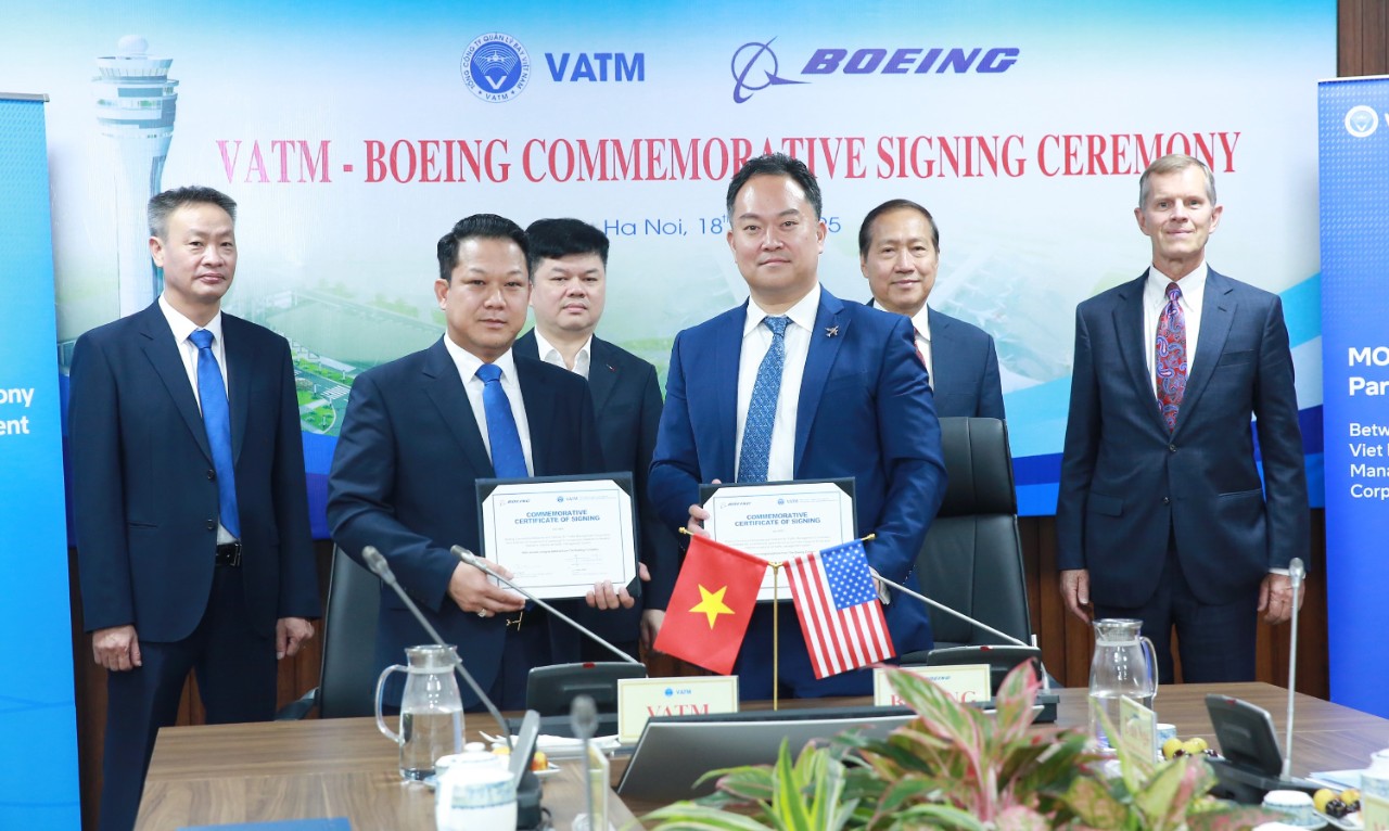 Boeing and VATM team in Hanoi exchanging documents at the MOU ceremony to jointly establish cooperative initiatives to enhance Vietnam’s national air traffic management system.